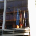 Flags are displayed in a modern building window.