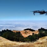 black drone on air over cloudy sky at daytime